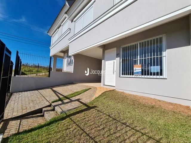 Fachada de uma residência em Lajeado, Brasil, com jardim e área pavimentada na frente.