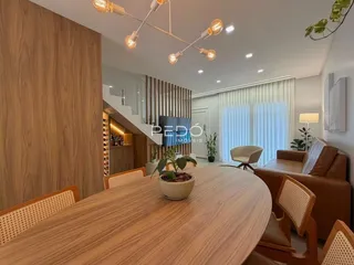 Vista de uma sala de jantar com mesa de madeira em um imóvel no Brasil.