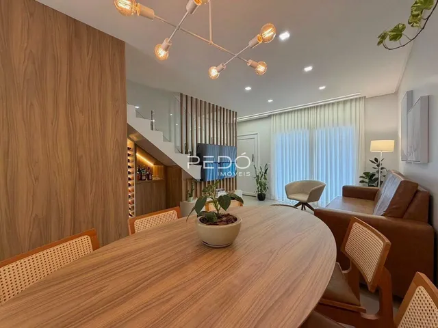 Vista de uma sala de jantar com mesa de madeira em um imóvel no Brasil.