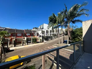 Vista da fachada de casas em Lajeado, Brasil, com vegetação e grade de segurança.