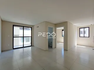 Ambiente interno de uma sala ampla com piso de cerâmica e portas de vidro.