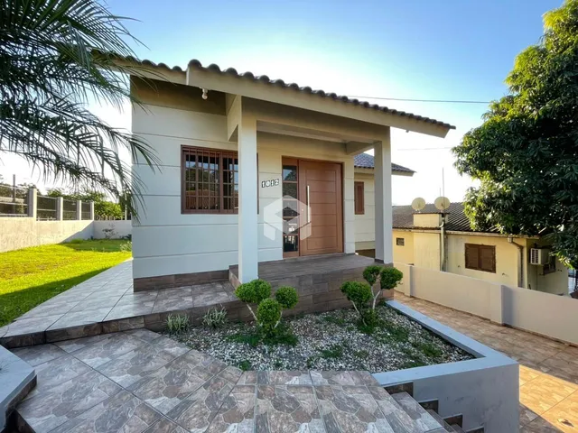 Fachada de uma casa em Lajeado, Brasil, com jardim e área externa pavimentada.
