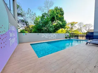 Vista externa de uma piscina e deck em uma propriedade residencial.