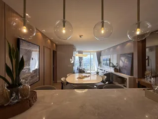Interior de uma sala de jantar com painéis de madeira e luminárias pendentes.