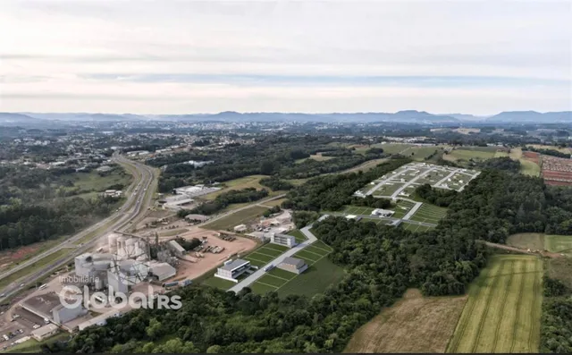 Vista aérea de uma área rural com trilhos de trem e estruturas industriais.
