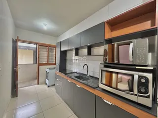 Esta é uma foto de uma cozinha moderna com armários cinzas e bancada escura.
