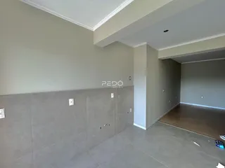 Foto do interior de um ambiente com paredes claras e piso de cerâmica.