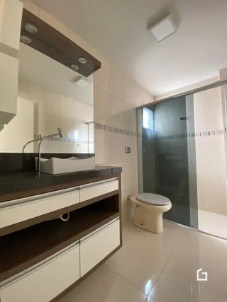 Vista de um banheiro com bancada e vaso sanitário em um imóvel.