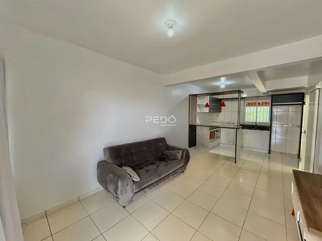 Sala de estar com sofá e piso de cerâmica em imóvel no Brasil.