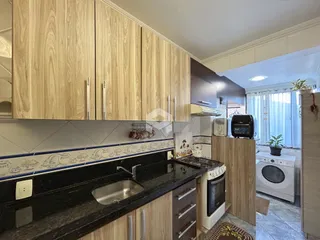Foto da cozinha com armários de madeira e bancada escura.