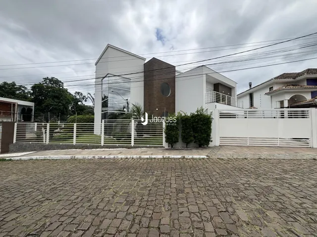 Fachada de uma residência em Lajeado, Brasil, com cerca e portão branco.