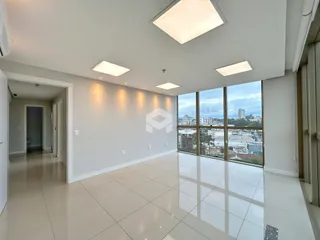 Sala ampla com piso de porcelanato e grandes janelas.