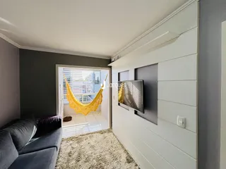 Sala de estar com parede em painel branco e porta de entrada para área externa