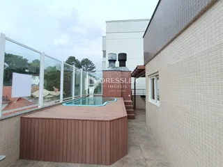 Vista de uma área externa com piscina e deck em uma residência.