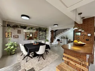 Sala de jantar com mesa escura e parede de madeira no imóvel em Lajeado.