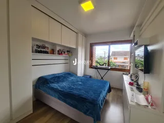 Quarto com armários brancos e piso de madeira.