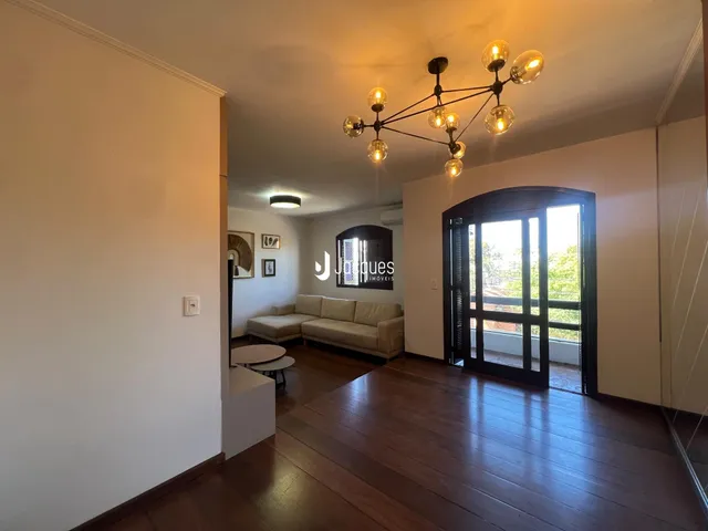 Sala de estar com piso de madeira e porta de vidro abrindo para o exterior.
