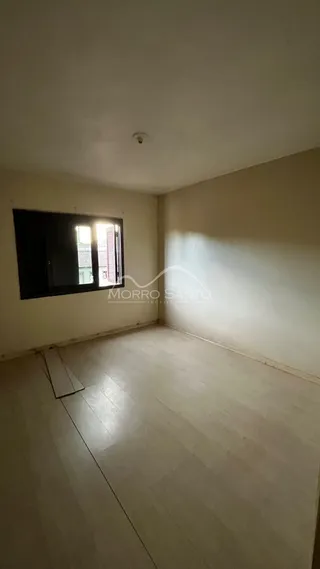 Foto de um cômodo interno com piso de madeira e uma grande janela.