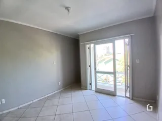 Vista interna de um ambiente com piso de cerâmica e porta de vidro.