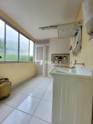 Banheiro com janela ampla e piso de cerâmica branca.