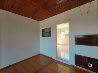 Interior de uma sala com piso de cerâmica e teto de madeira.