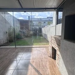 Área externa com piso de cerâmica e vista para o jardim.