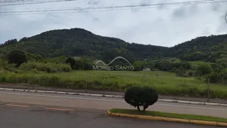 Vista da paisagem rural com colinas verdes ao fundo, com uma estrada no primeiro plano.