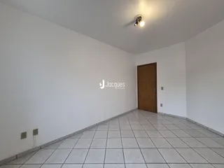 Corredor interno com piso de cerâmica e paredes brancas.