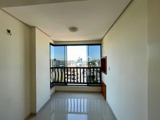Corredor interno com vista para a cidade através de uma grande janela.