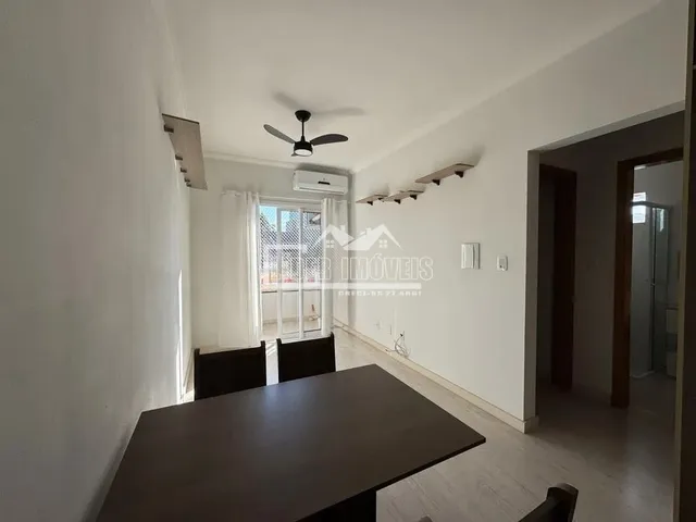 Corredor interno de uma residência com paredes brancas e piso de madeira.