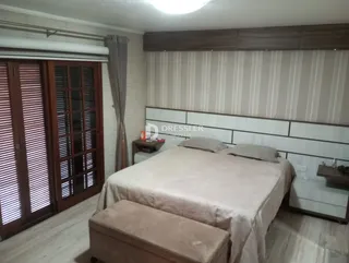Quarto com cama e portas de madeira em um imóvel.