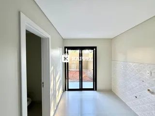Hall de entrada com portas de vidro que dão acesso a uma área externa.