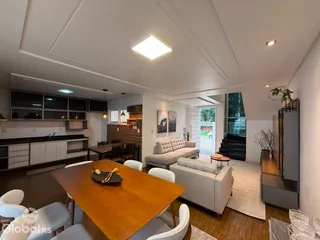 Sala de estar e cozinha de um apartamento moderno com mesa de jantar.