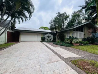Vista da fachada de uma casa com garagem e calçada de piso claro em Lajeado.