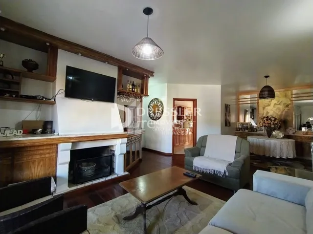 Sala de estar com lareira e painel de madeira em um imóvel.