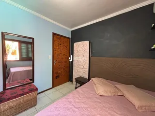 Quarto com cama e porta de madeira em um imóvel no Brasil.
