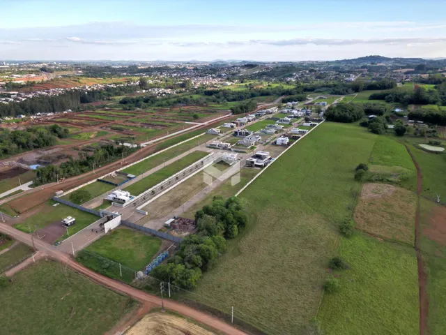 Vista aérea de uma propriedade rural com campos verdes e área de desenvolvimento na paisagem de Lajeado.