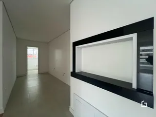Corredor interno de uma residência com paredes brancas.
