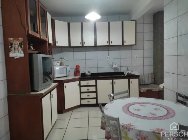 Foto de um ambiente interno com armários de madeira e uma mesa redonda.