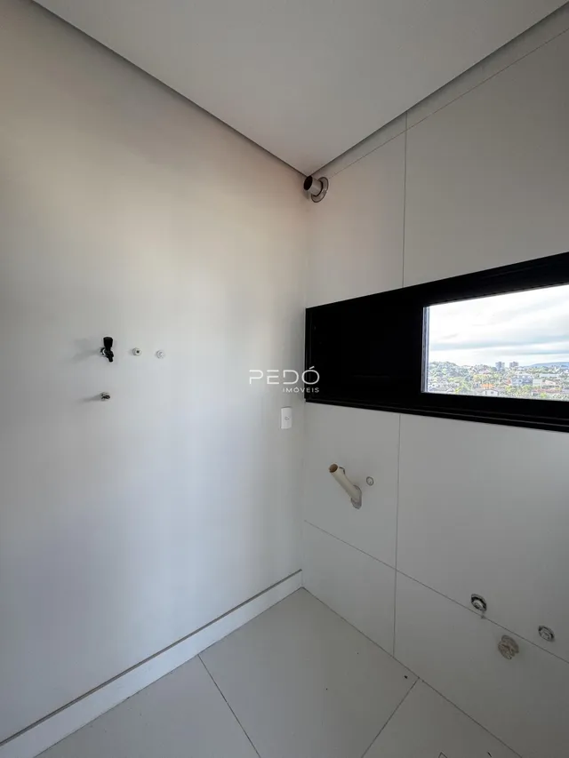 Interior de um banheiro com paredes brancas e piso claro.