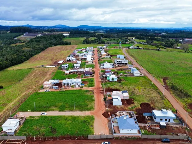 Vista aérea de um loteamento residencial com casas em construção e áreas verdes em Lajeado.