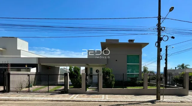 Fachada de uma residência moderna em Lajeado, Brasil, com cerca e portão.