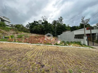 Vista externa de uma propriedade com terreno inclinado e vegetação densa.