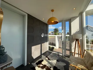 Sala de estar com portas de vidro que dão acesso a uma área externa.