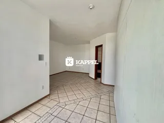 Corredor interno com piso de cerâmica e paredes brancas.