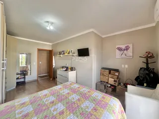 Quarto com cama e porta de madeira em uma residência.