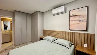Quarto com cabeceira de madeira e roupa de cama branca.