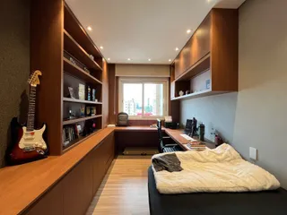 Quarto com estantes de madeira e área de trabalho.