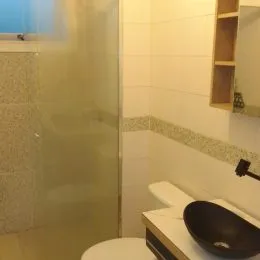 Foto de um banheiro com revestimento de azulejos brancos.