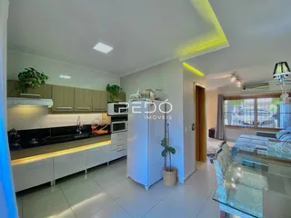 Sala de estar e cozinha moderna com armários de madeira e piso de cerâmica.